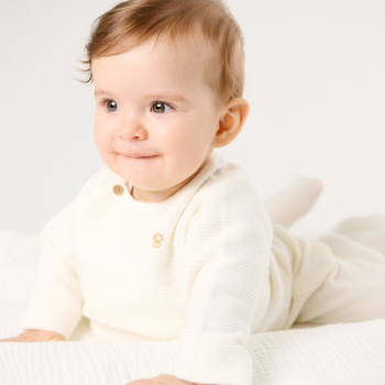 Newborn's wrap-around white and ecru knitted cardigan